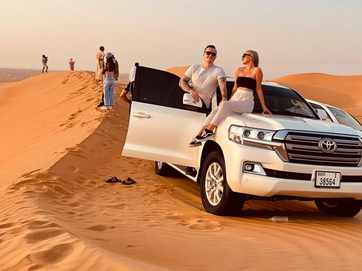 Land Cruiser 4x4 parked on a red dune during a Dubai desert safari