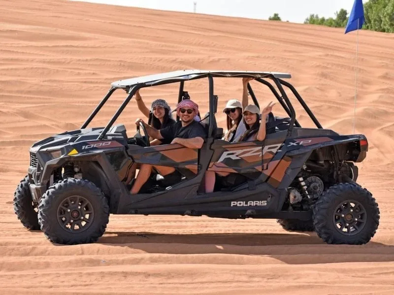 Family and friends riding a 4 seater dune buggy in the Abu Dhabi desert