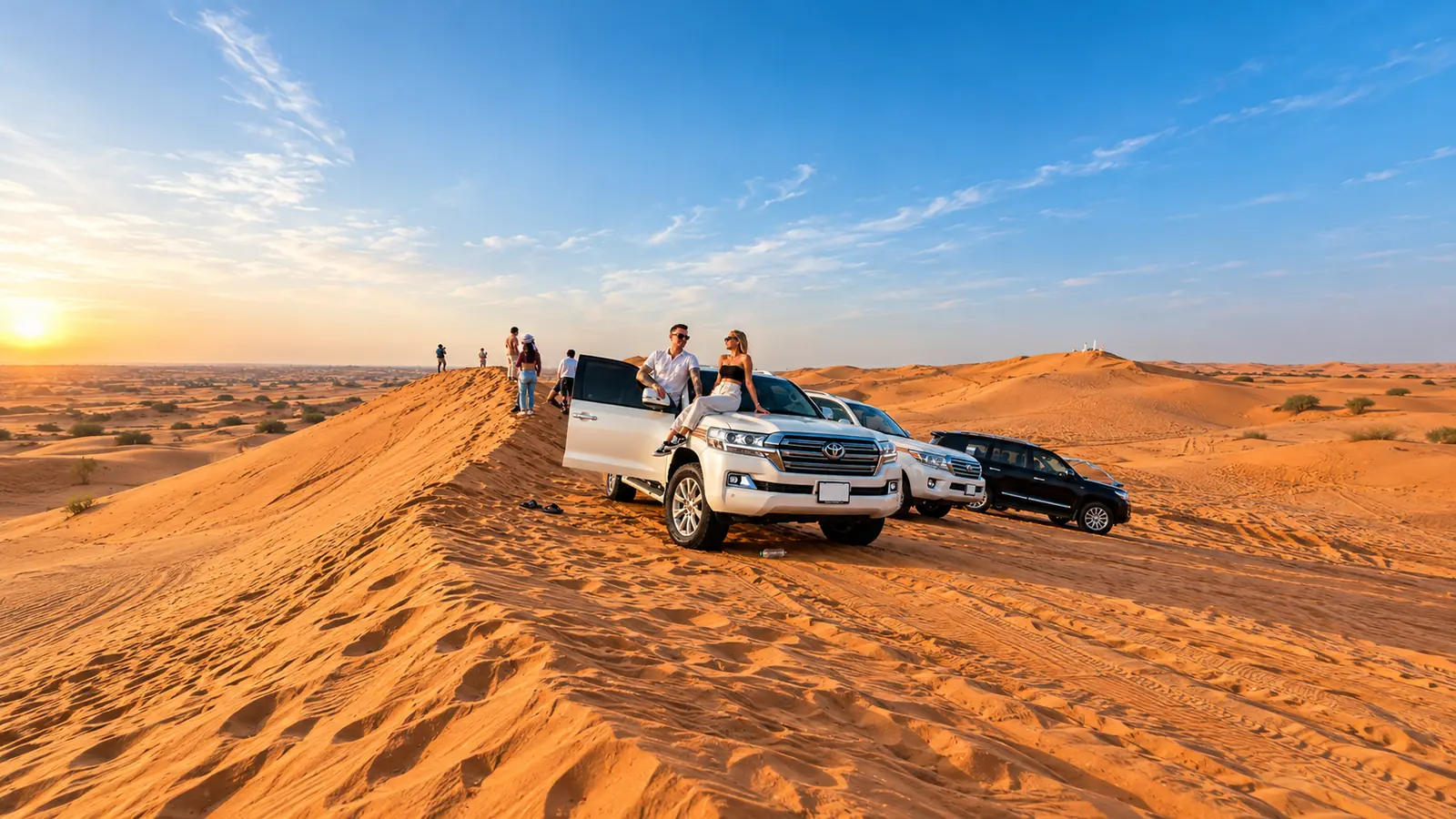 Couple with a white Toyota Land Cruiser convoy on Abu Dhabi dunes at sunset during a Private Safari with ATV + VIP
